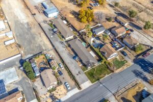 Aerial view of a residential neighborhood in Yucaipa, CA, showing houses, yards, and streets.