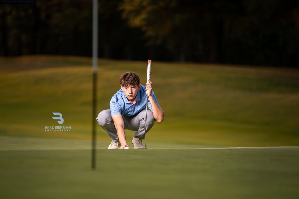 Golf senior portrait of Trey, Althoff Catholic High School golfer, lining up a putt on a St. Louis golf course