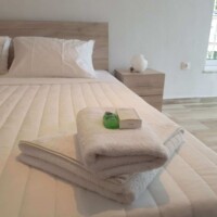Panorama House – διπλό κρεβάτι με λευκά λινά, πετσέτες & amenities δίπλα στο παράθυρο