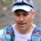 Running enthusiast in outdoor gear during a trail run in nature.