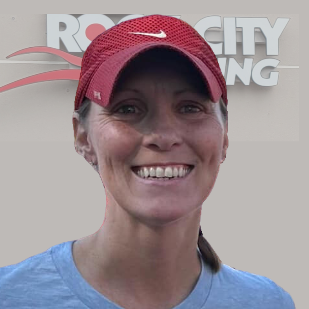 Bright smiling woman wearing a red running cap and blue athletic shirt at Rock City Running store in Little Rock Arkansas, promoting local running shoes and gear.