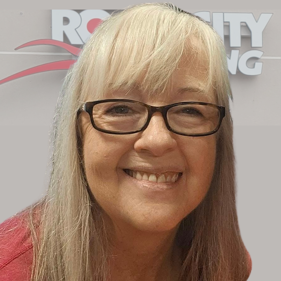 Comfortable woman wearing glasses smiling at Rock City Running store in Little Rock Arkansas, promoting local and online running gear.