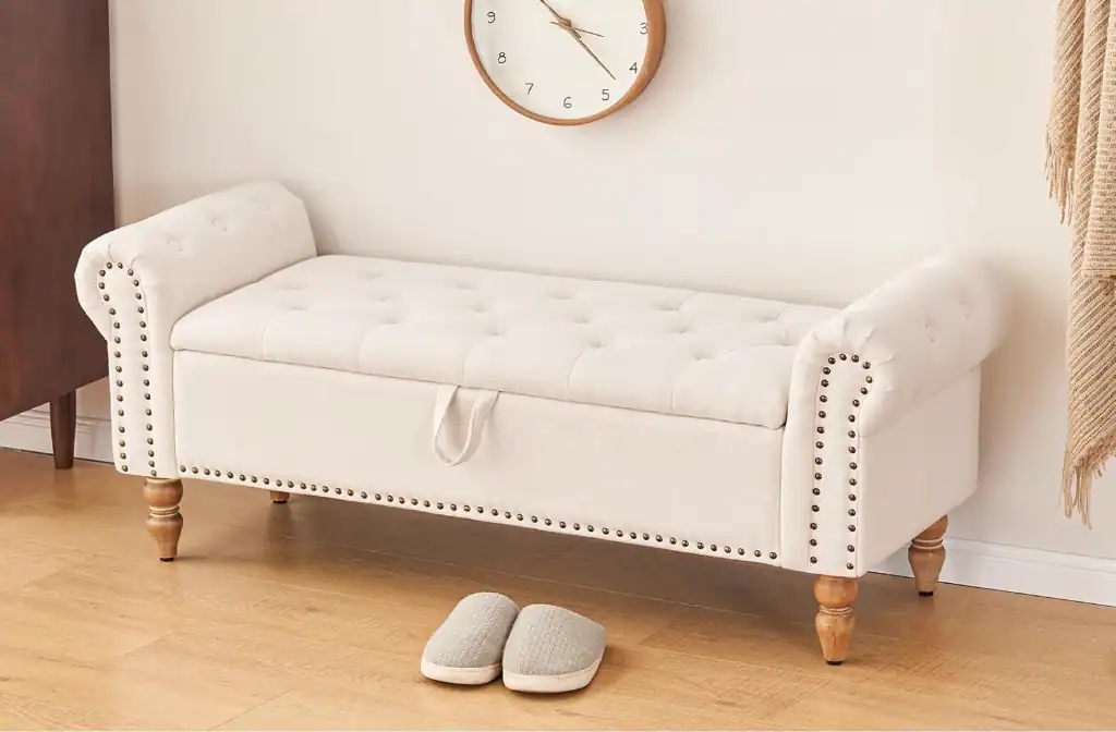 Comfortable white upholstered entryway bench with wooden legs and slippers.