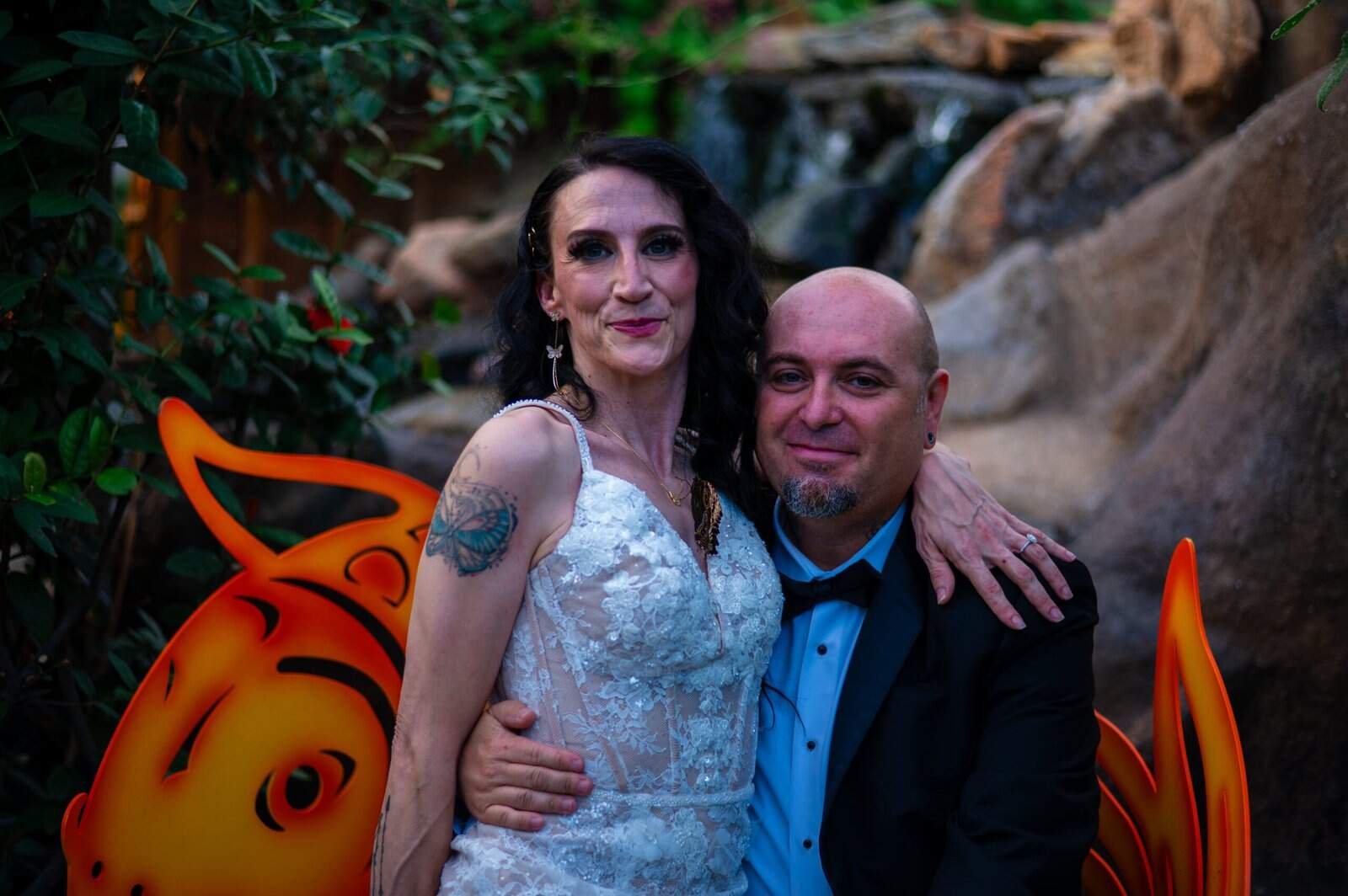 A happy bride and groom pose together at their wedding, showcasing love and celebration.