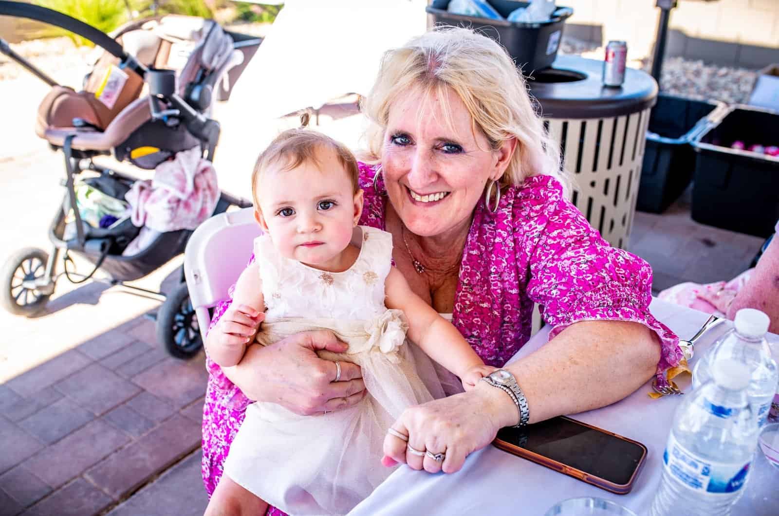 A joyful grandmother holding a young girl at a family event, showcasing special moments and family bonding.