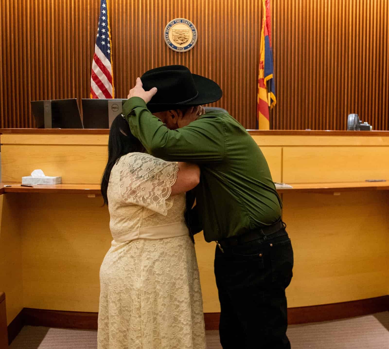A heartfelt moment between a bride and groom during their wedding in a courtroom, capturing love and commitment.