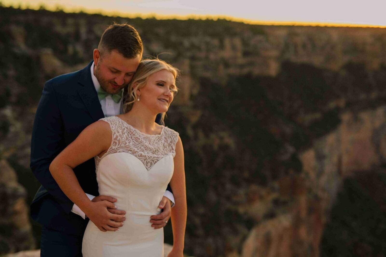 Beautiful wedding photo of a bride and groom sharing a moment in nature during sunset.
