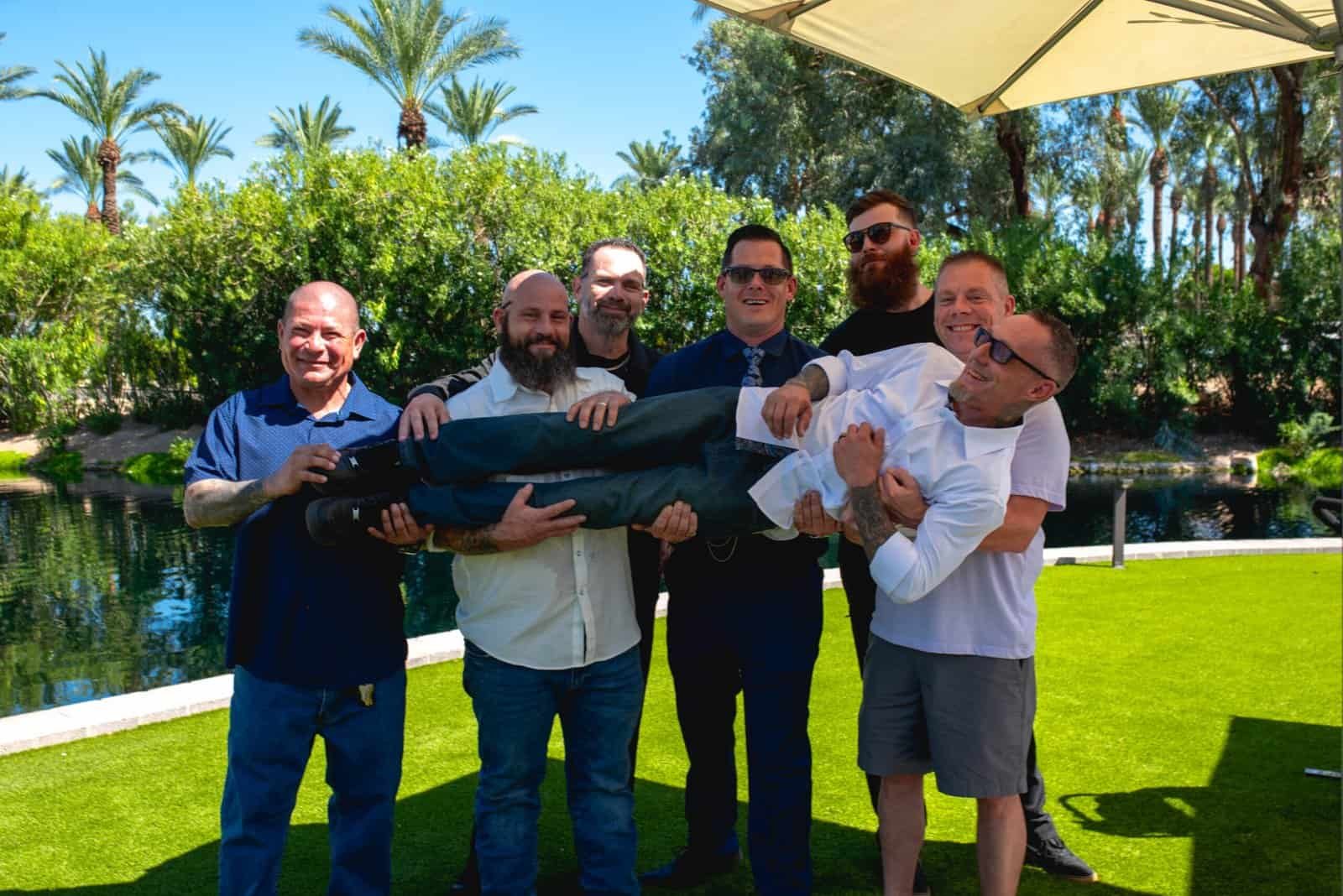 Group of friends enjoying a fun moment together in a lush garden setting.
