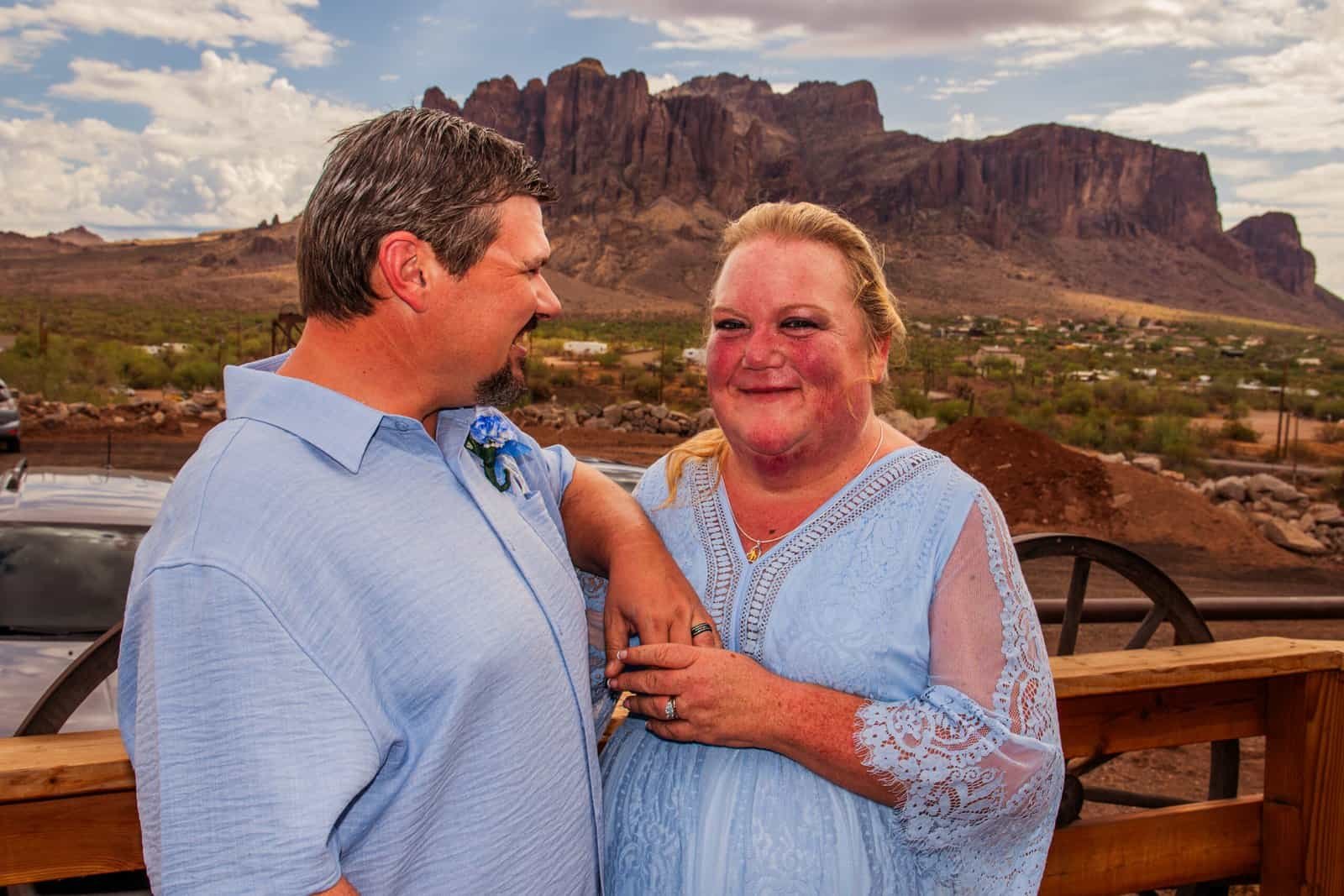 A heartfelt scene of a mother and son sharing a joyful moment outdoors, with stunning desert landscape and mountains behind them.