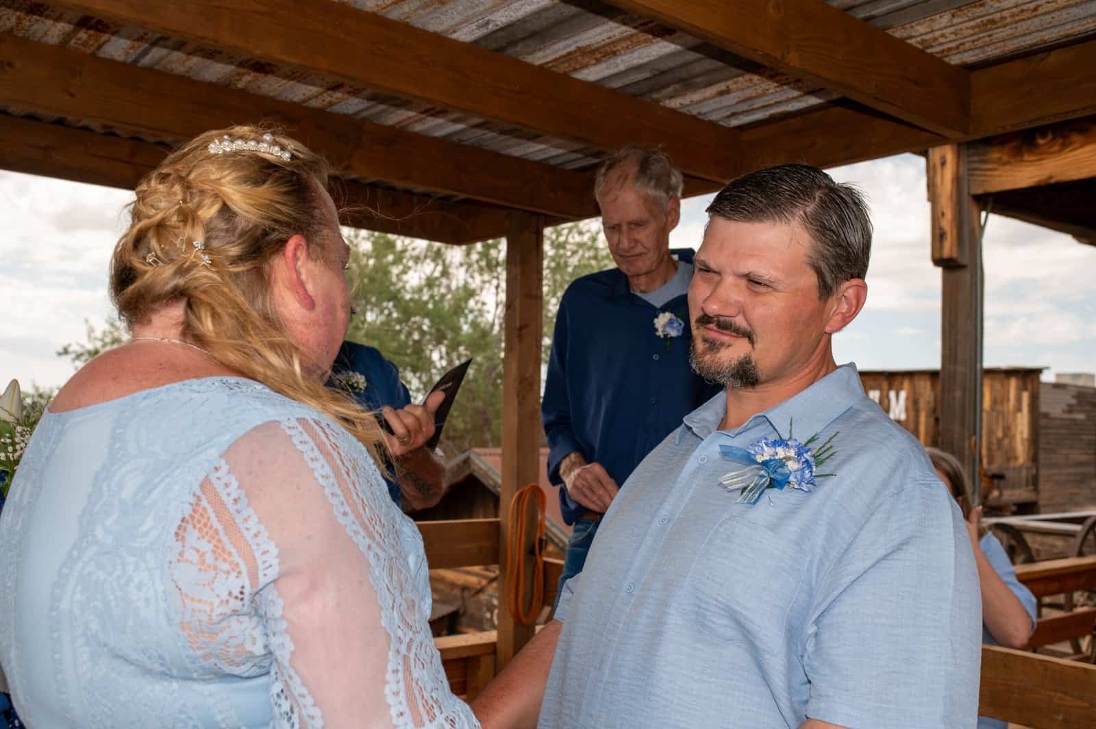 A heartfelt wedding moment with bride and groom holding hands during vows.