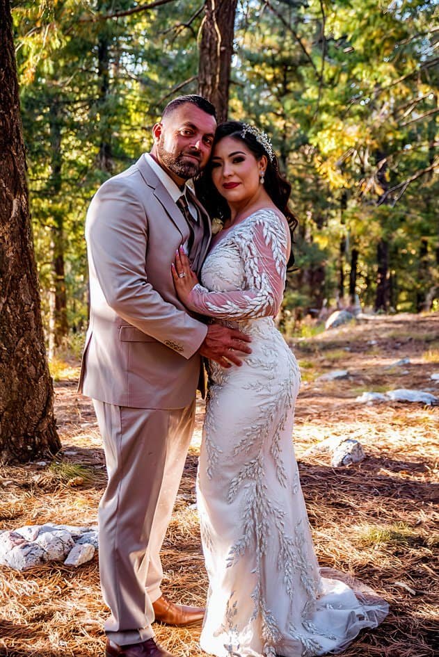 A bride and groom in wedding attire sharing a romantic moment in a scenic forest setting, perfect for wedding videography.