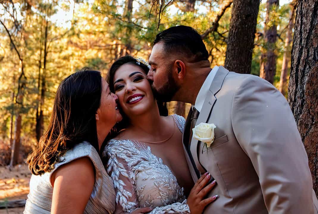 Beautiful moment of the bride and groom sharing a kiss in a forest setting during their wedding.