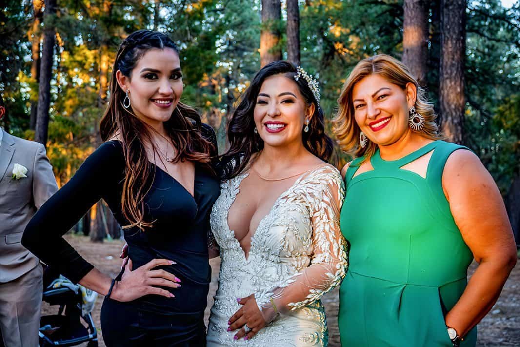 Group of women enjoying a joyful moment at an outdoor celebration in the woods.