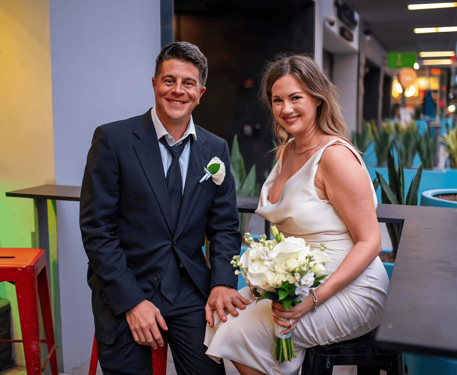 A happy bride and groom at a wedding reception, showcasing their love and joy during a special moment.
