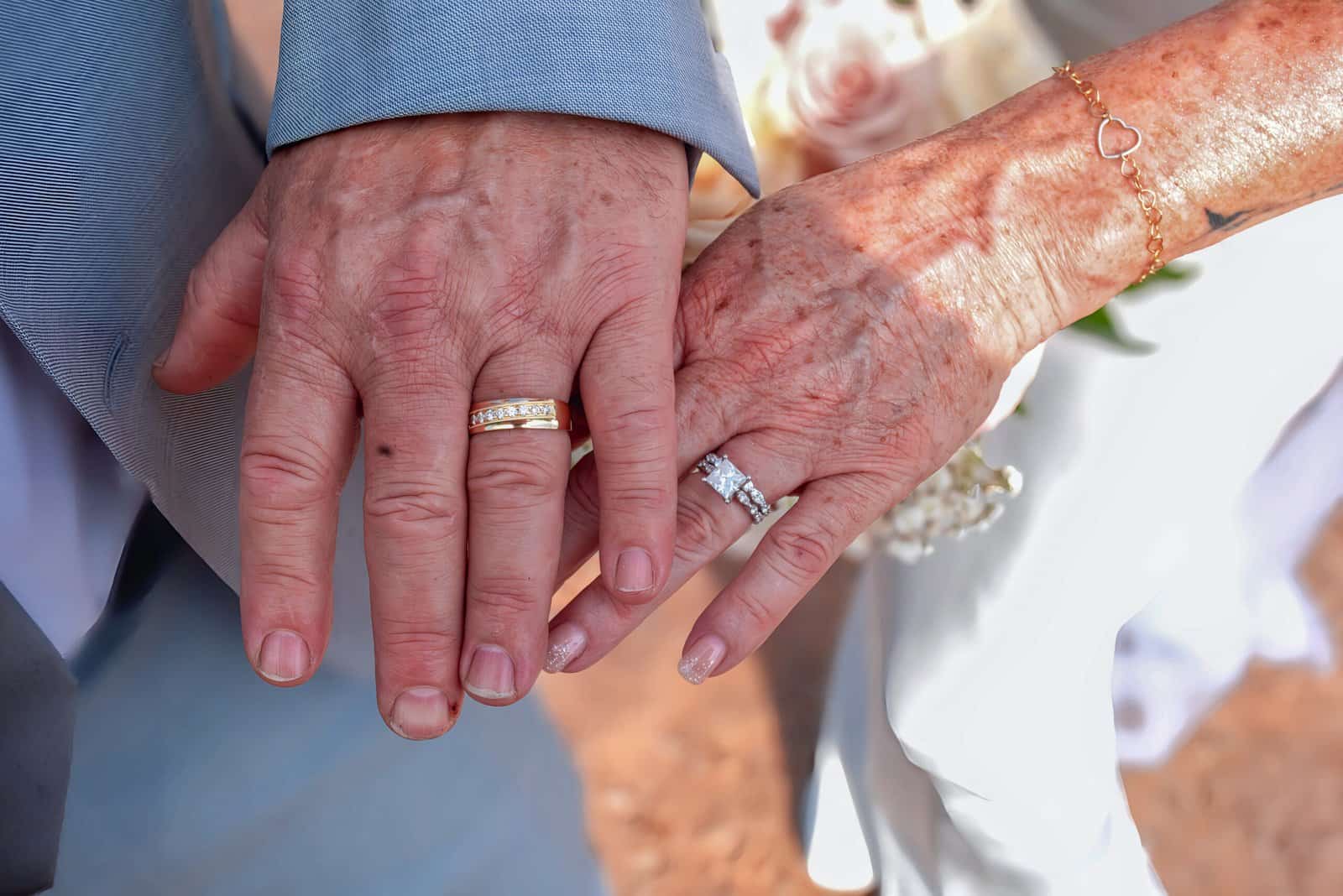 Close-up of senior couple's hands with wedding rings, symbolizing lifelong love and partnership.