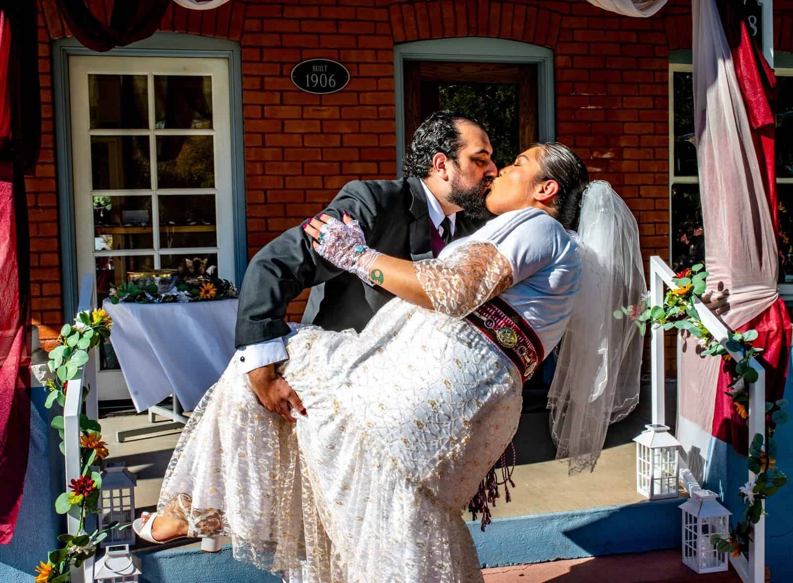 Romantic wedding moment with a couple kissing outdoors, celebrating love and union.
