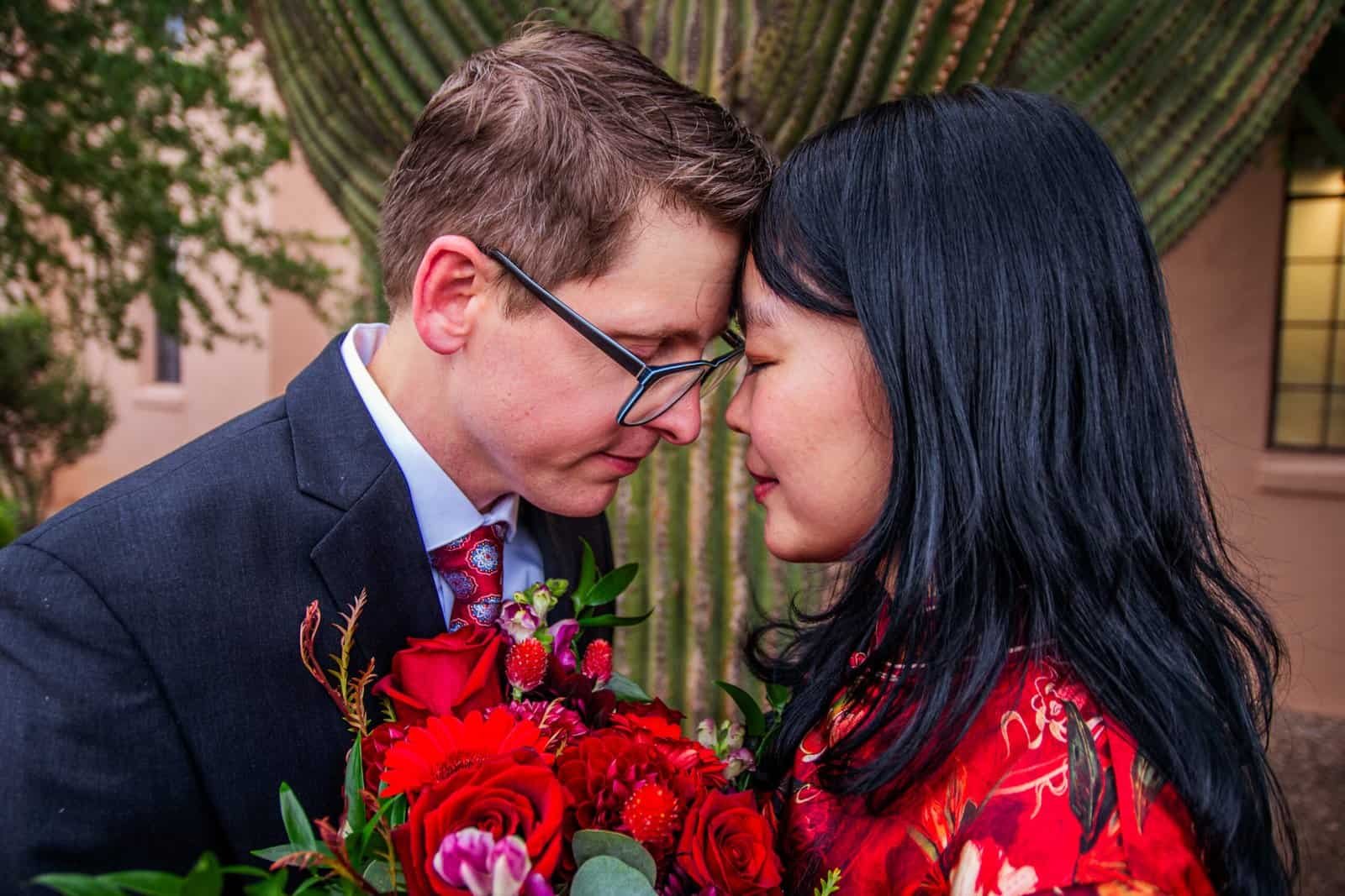 A couple sharing an intimate moment with a bouquet of flowers, highlighting love and connection, perfect for wedding videography and special event cov.