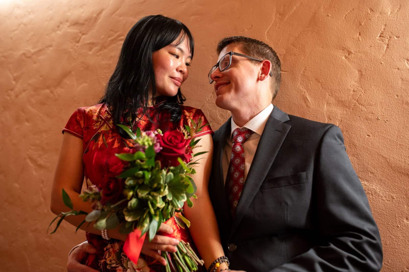 A couple sharing a tender moment, woman with a bouquet, capturing love and happiness.