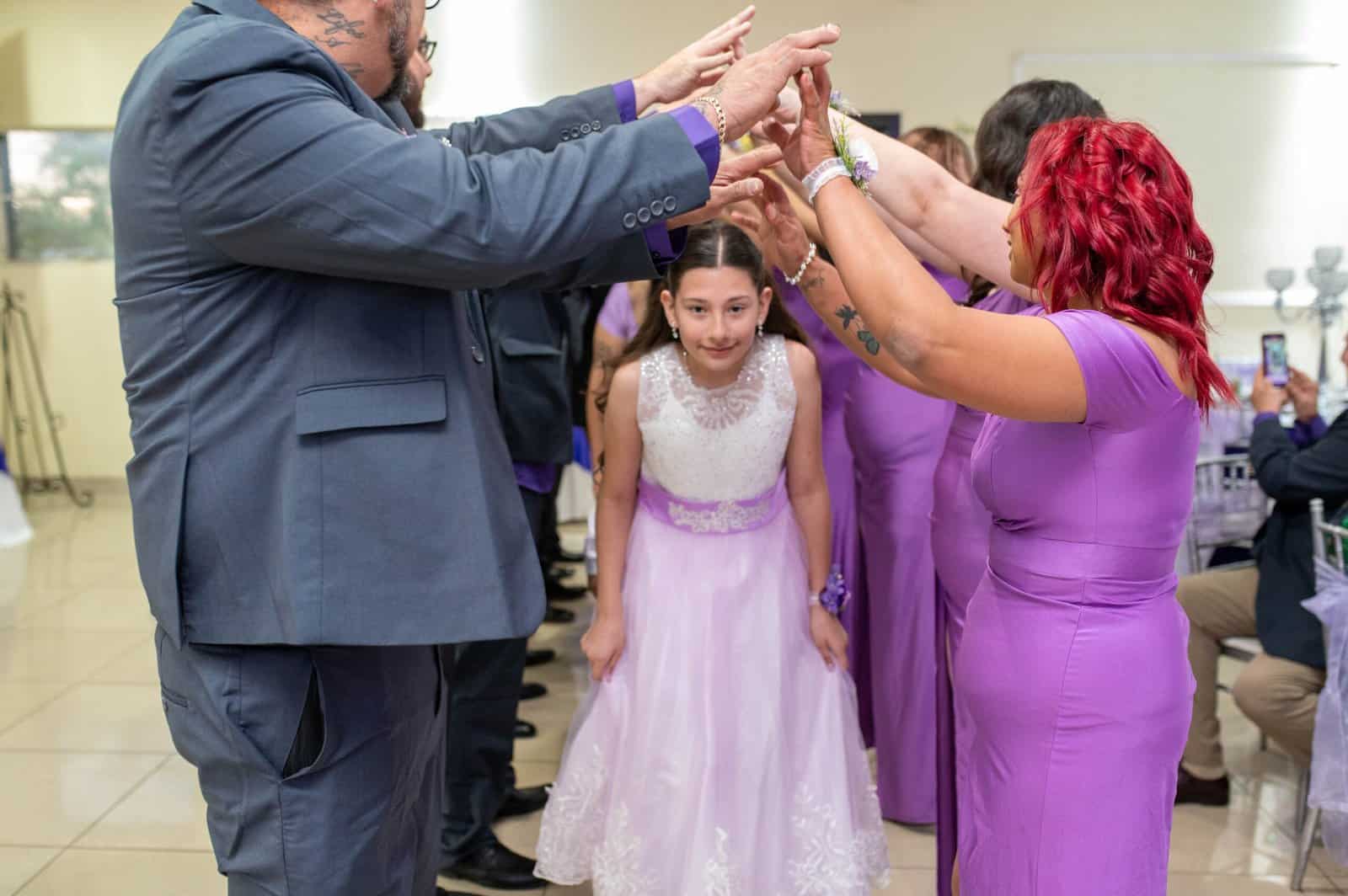 Joyful family and friends dance together, celebrating a special moment with a young girl in a beautiful dress.