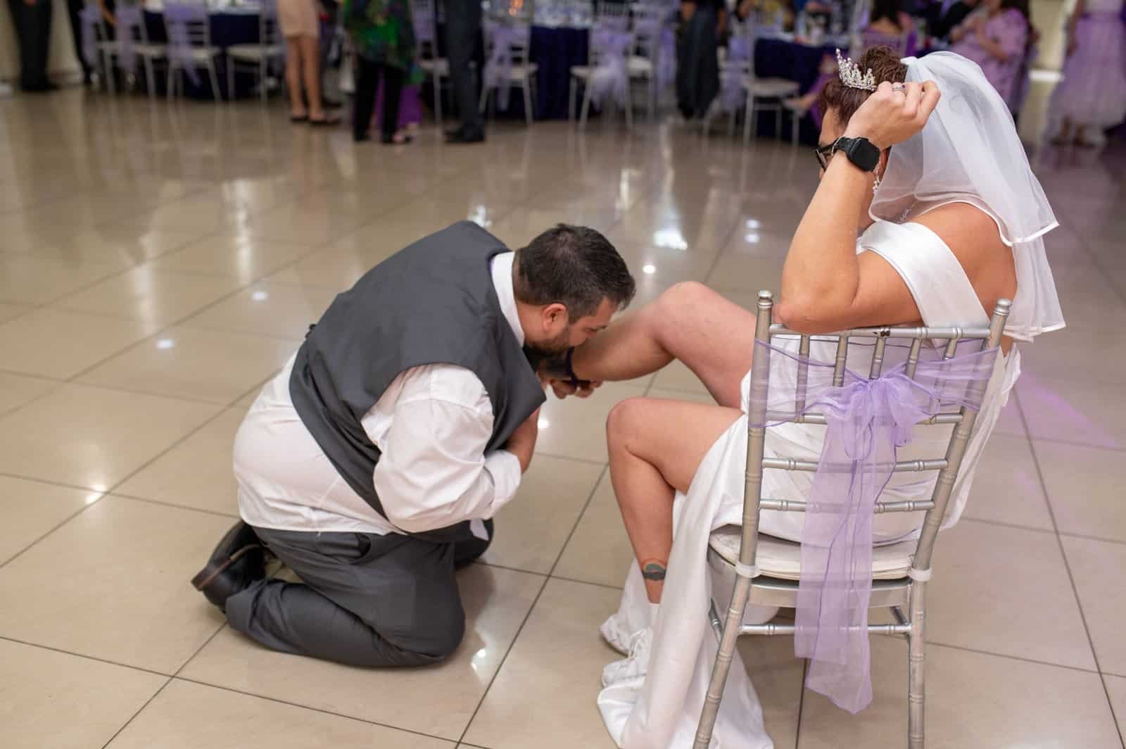 Romantic wedding proposal scene with groom proposing to bride at reception.