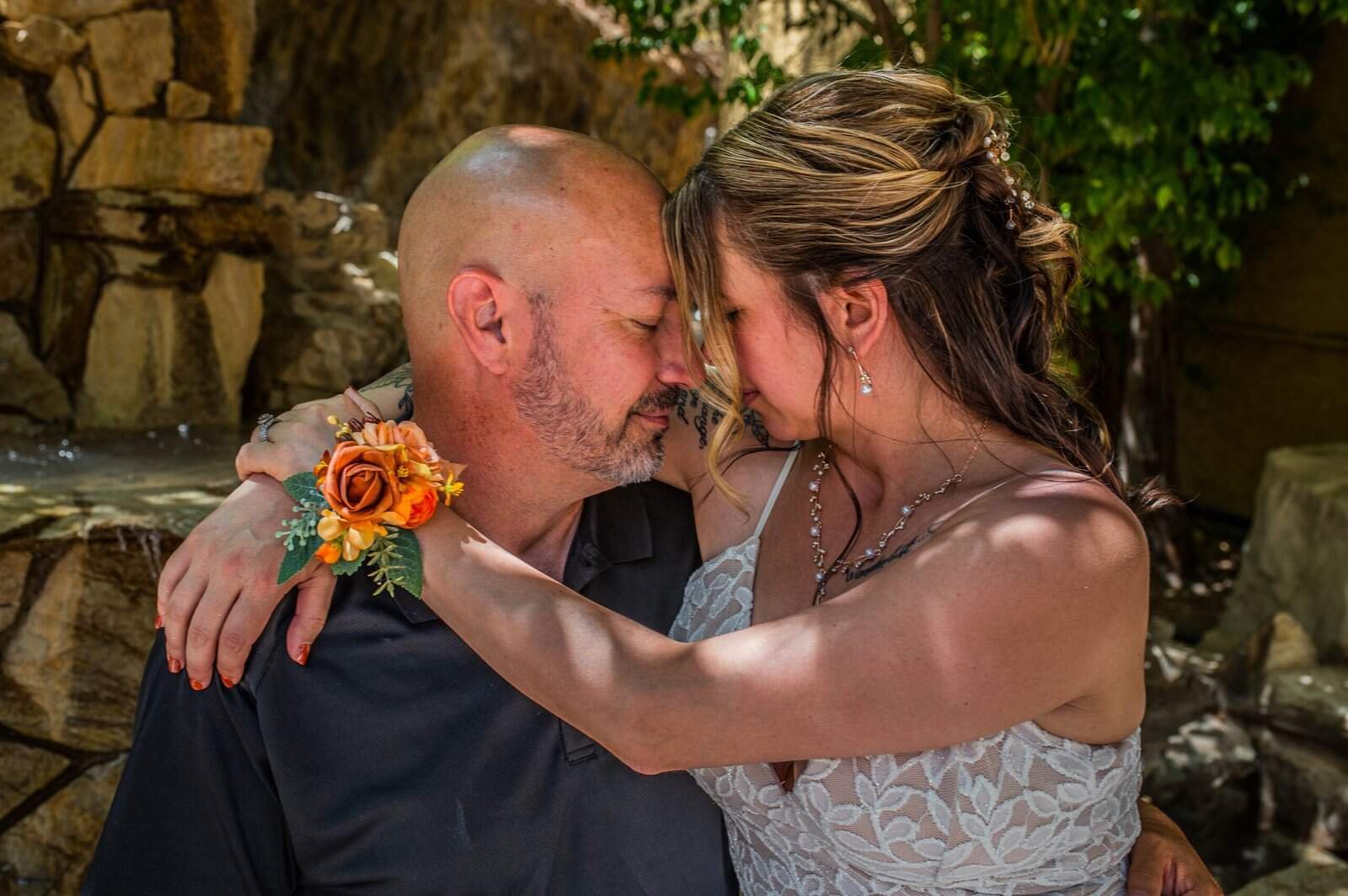 Intimate wedding scene with a bride and groom embracing outdoors, capturing love and happiness on their special day.