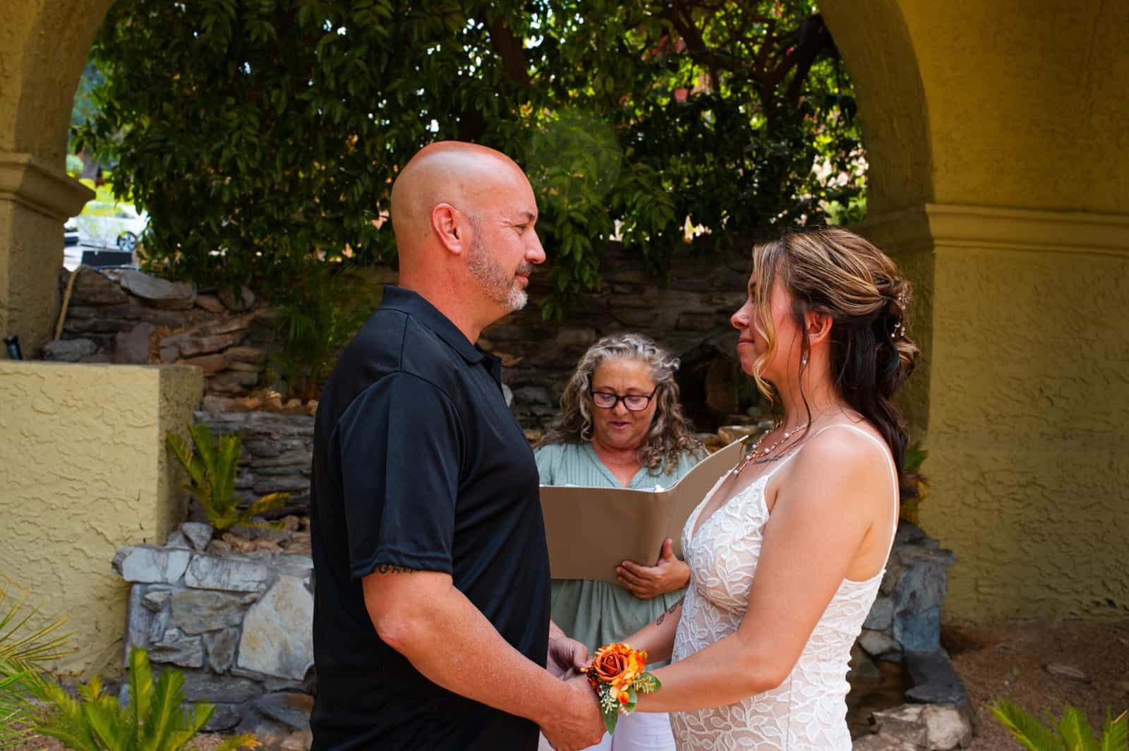 Beautiful outdoor wedding with couple holding hands and exchanging vows, surrounded by nature.