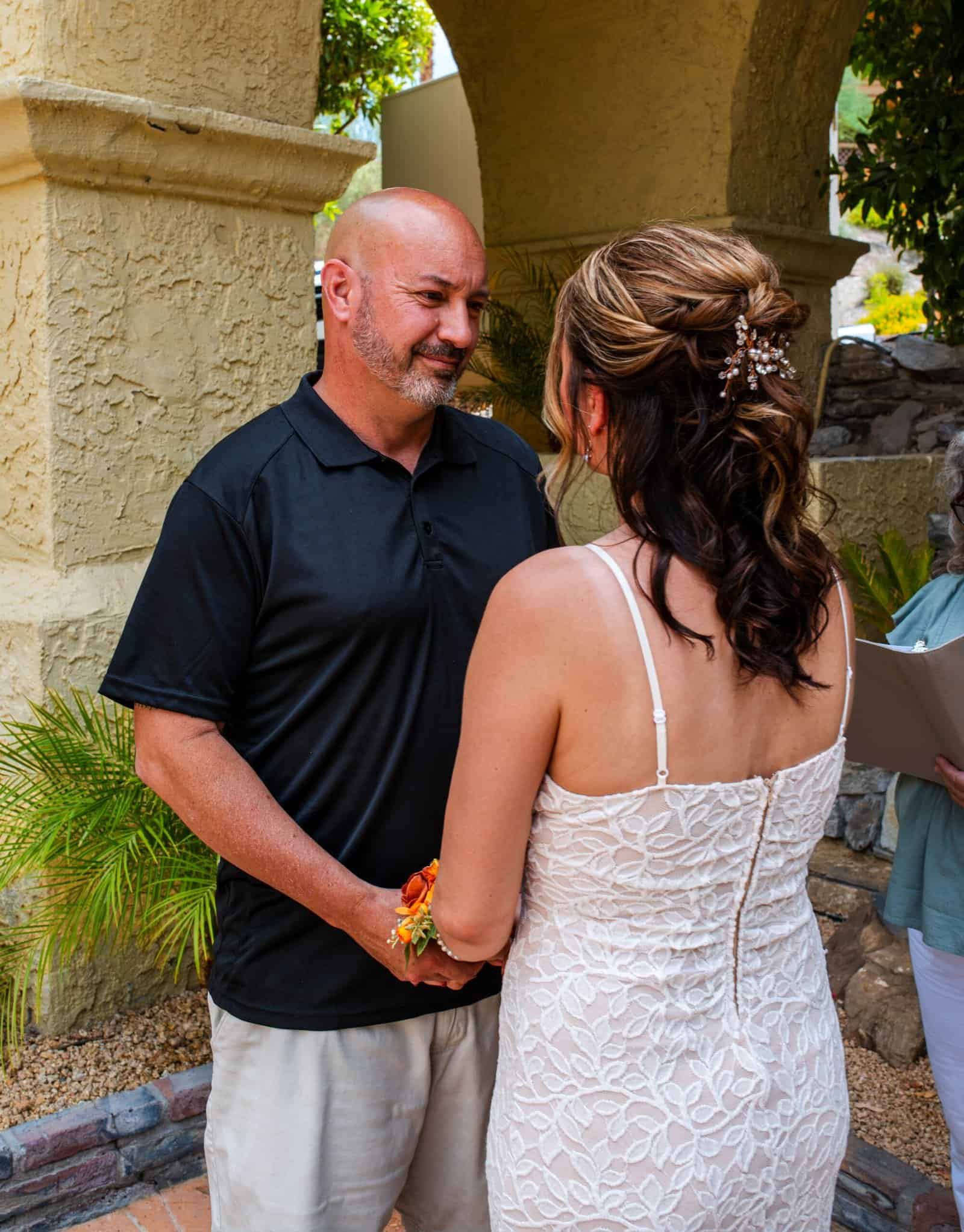 A heartfelt moment as a bride and groom share vows in a beautiful outdoor setting.