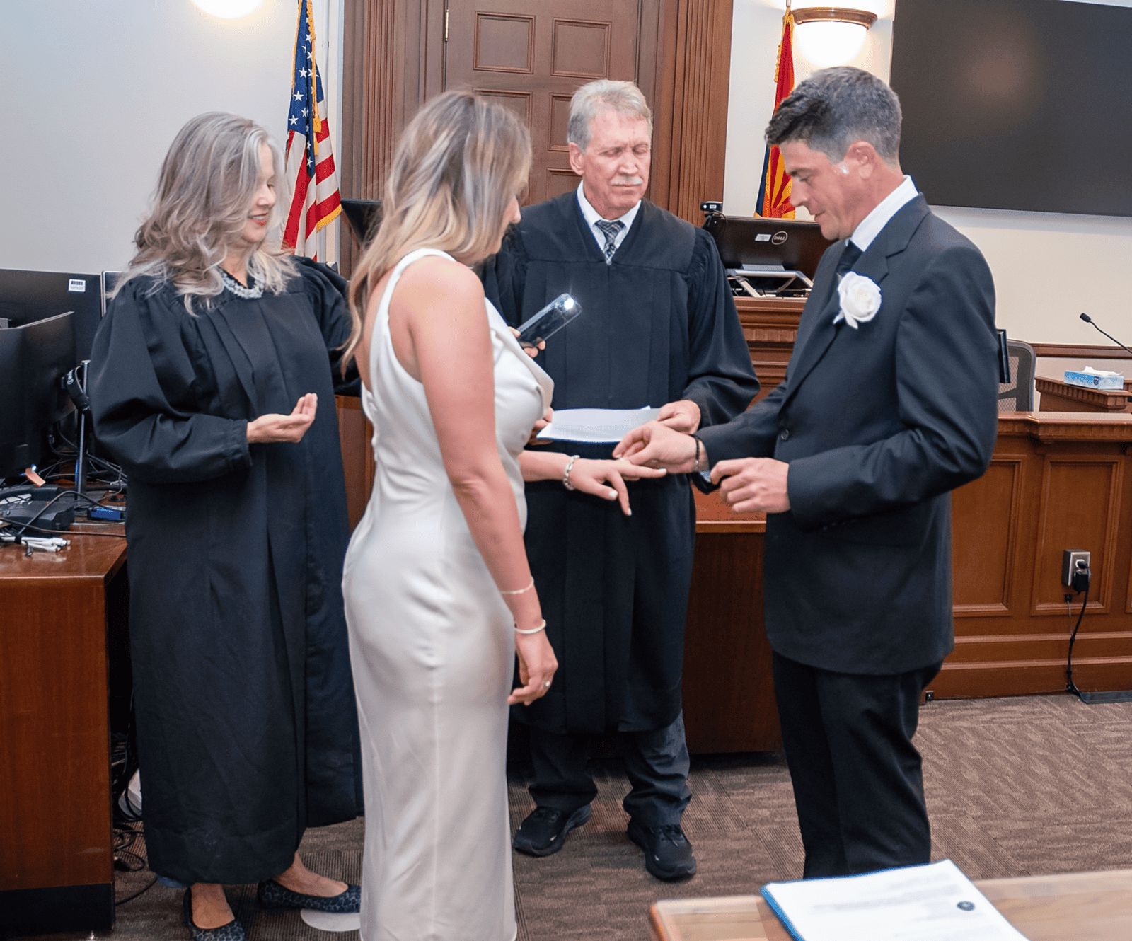 Wedding ceremony capturing the couple's vows with judge officiating in a formal courtroom environment.