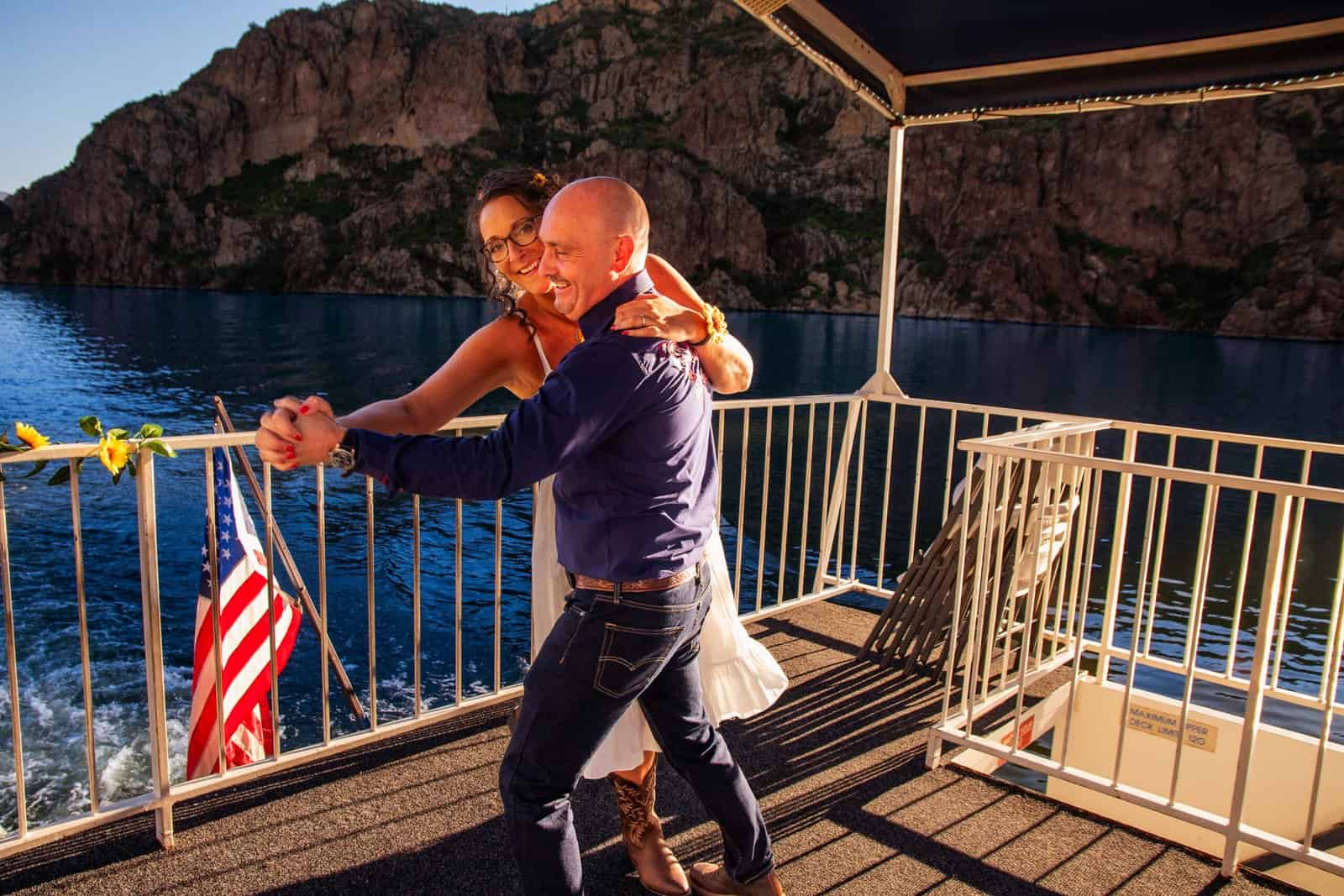 Romantic couple dancing on a boat deck during sunset, capturing joyful moments and scenic views for special occasions.