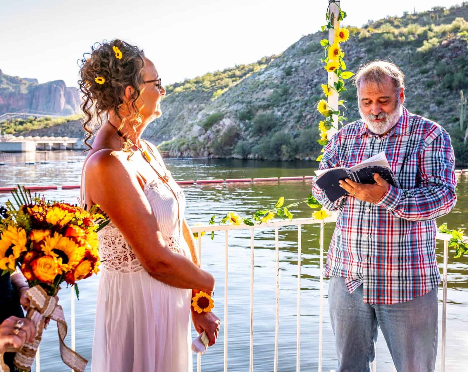 Beautiful outdoor wedding ceremony by the water, capturing a special moment between the couple.