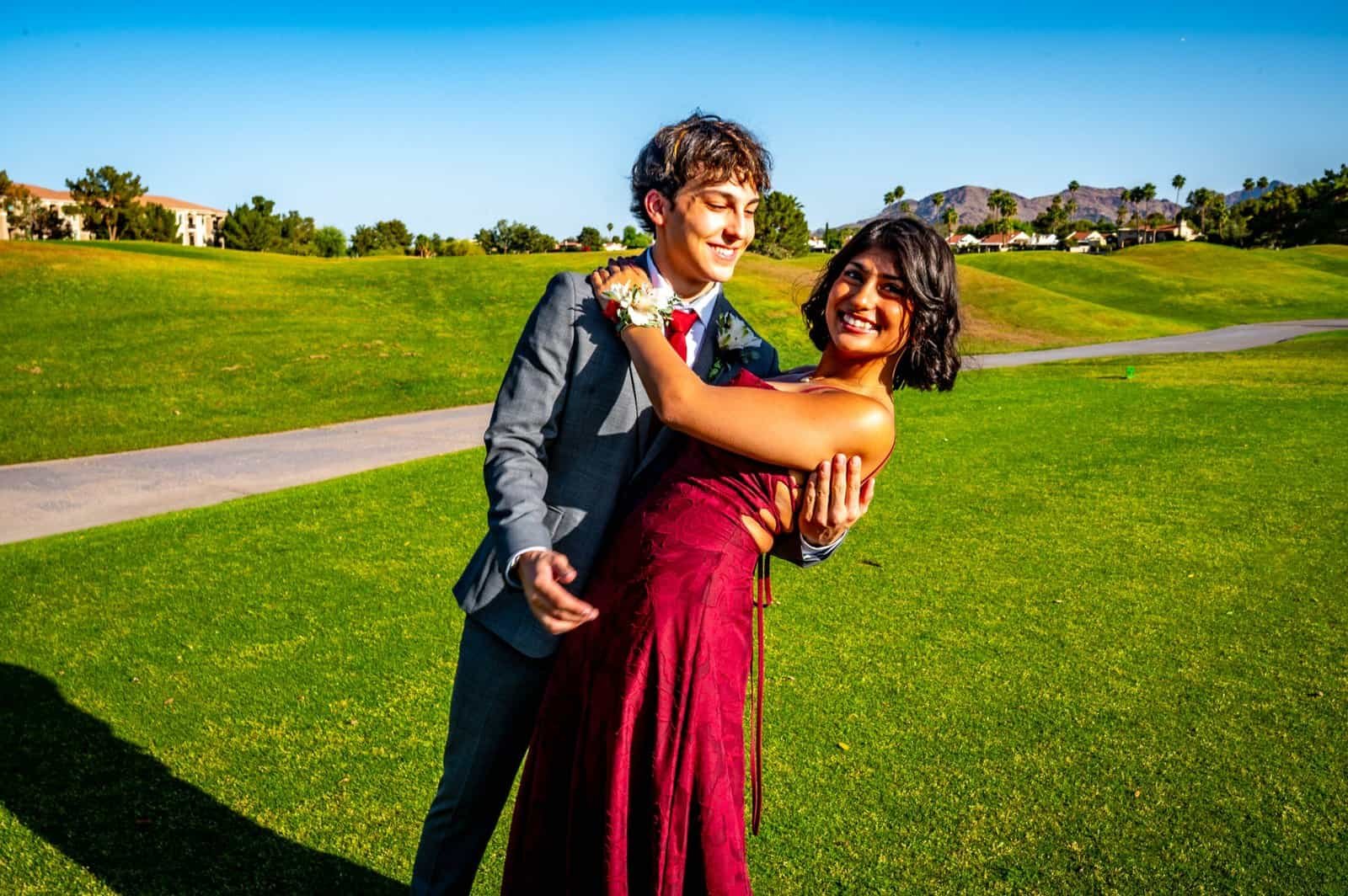A happy couple enjoying a dance outdoors on a vibrant green lawn, perfect for capturing memorable wedding or special event moments.