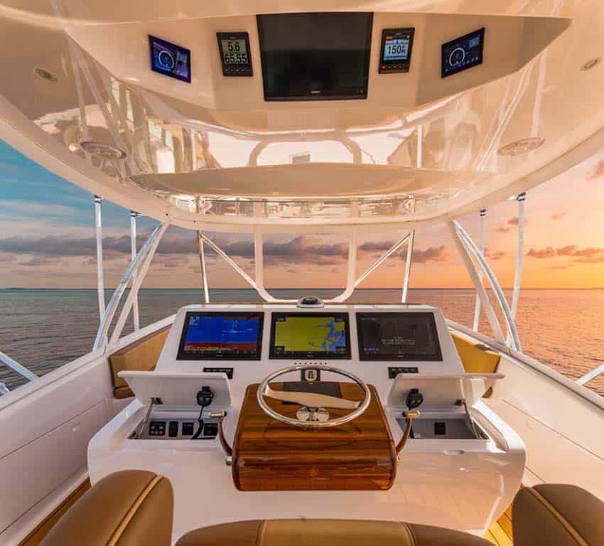 Luxury yacht helm with navigation screens at sunrise on open water