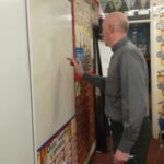man writing on wall board