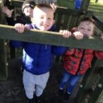 Small boy looking over fence