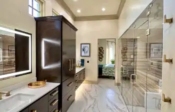 A double floating vanity with rich wood cabinetry and integrated under-cabinet lighting provides both storage and visual impact from Stanton and Company.