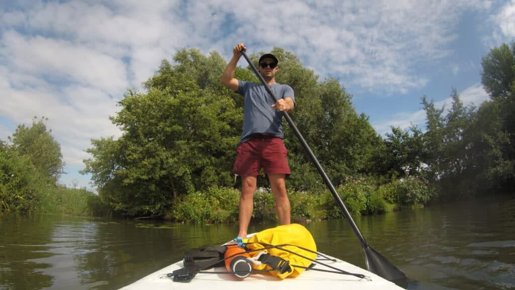 33 Fun Adventure Ideas: The Ultimate Adventure Bucklist 9 Paddle boarding down a river.