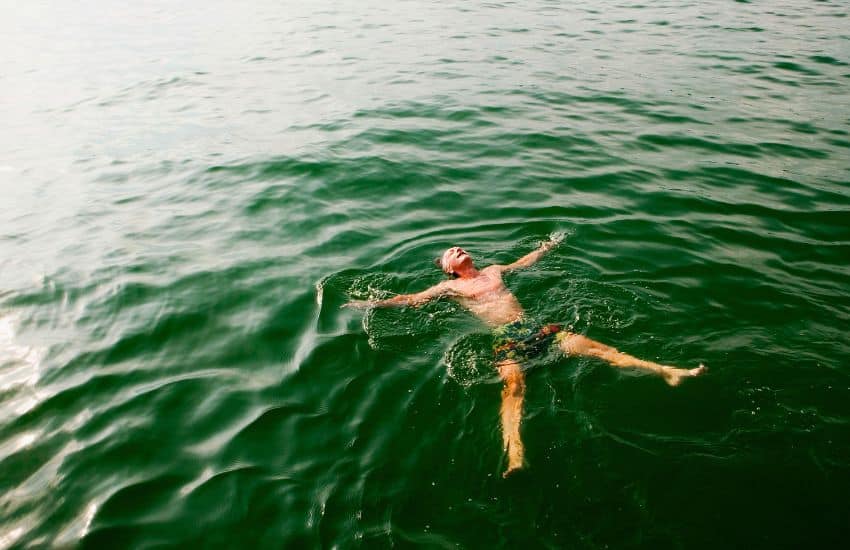9 Benefits of Cold Water Swimming to Improve Your Health 8 Man floating on water.
