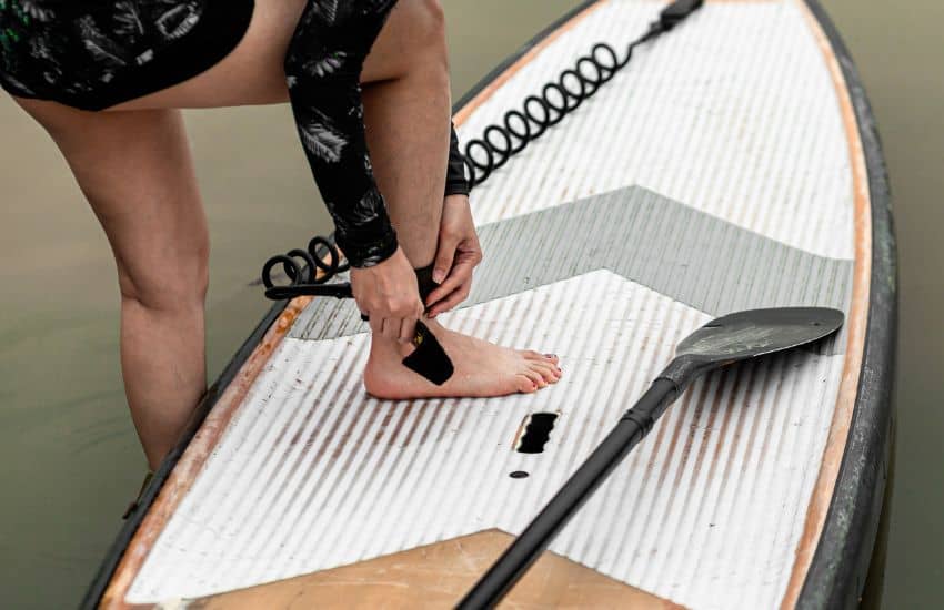 19 Things I Wish I Knew When I Started Stand Up Paddle Board 17 Paddler attaching leash to their ankle