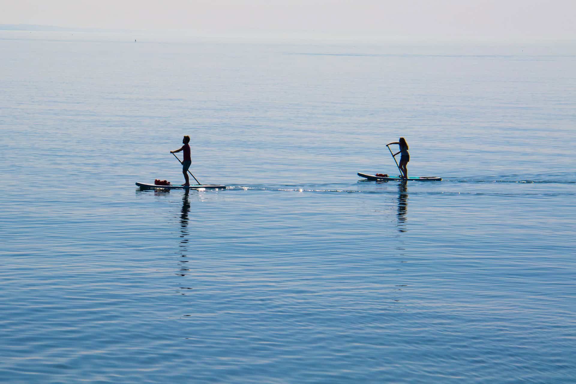 Paddleboard Sizes Guide: Choose the Right SUP (2025) 15 two paddleboarders on open water
