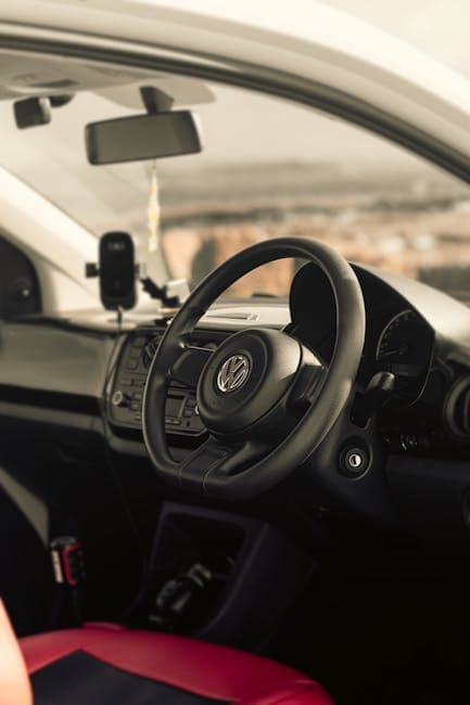 Interiør af bil med Volkswagen rat og GPS-navigation.