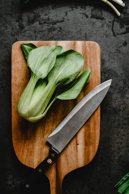 Frisk pak choi grøntsag med kniv på skærebræt til madlavning.