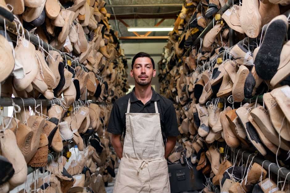 Mand står mellem hylder med mange forskellige sko i en butik.