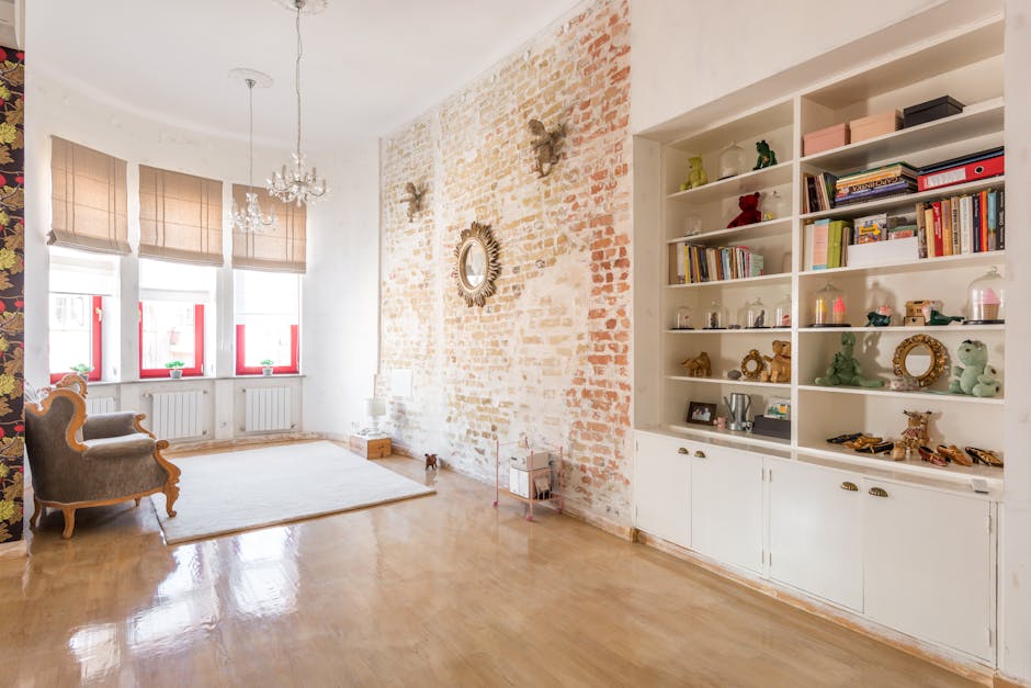 Billede af en hyggelig stue med bogreol, store vinduer og elegant indretning.