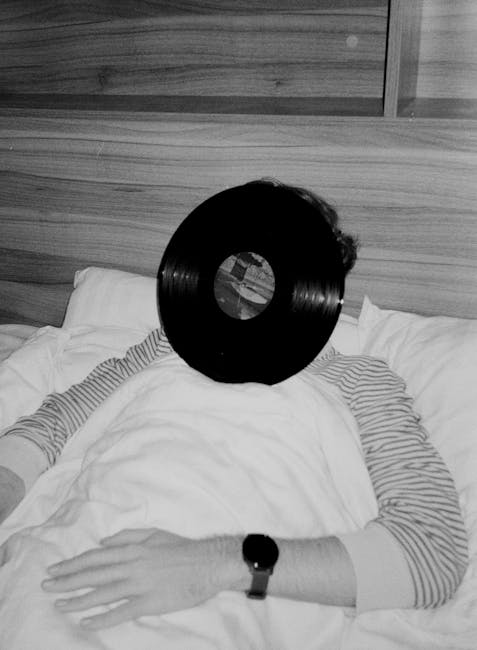 Person med vinylskive som ansigt, ligger i seng, afslappet stemning.