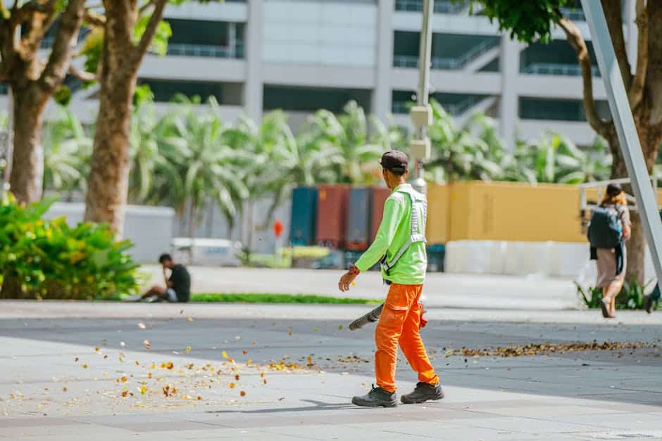 Skateboarder på gade i bymiljø med grønne træer og moderne bygninger.