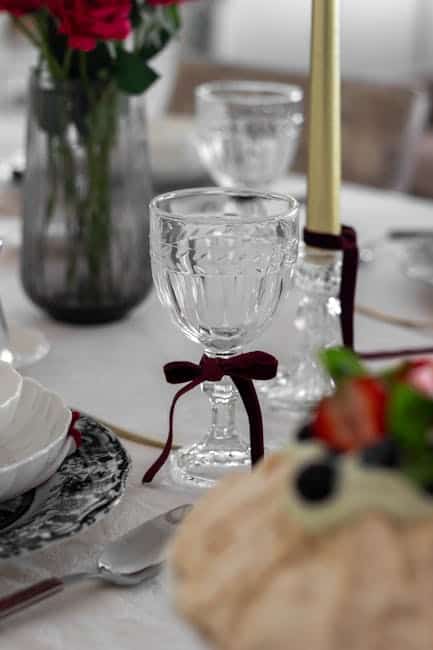 Festbord med glas, blomster og stearinlys til festlige lejligheder. Perfekt til middage og særlige b.