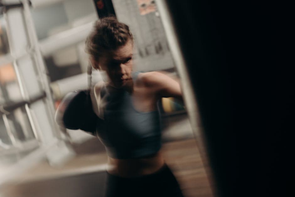 Kvinde træner styrketræning i fitnesscenter med fokus på muskelopbygning.