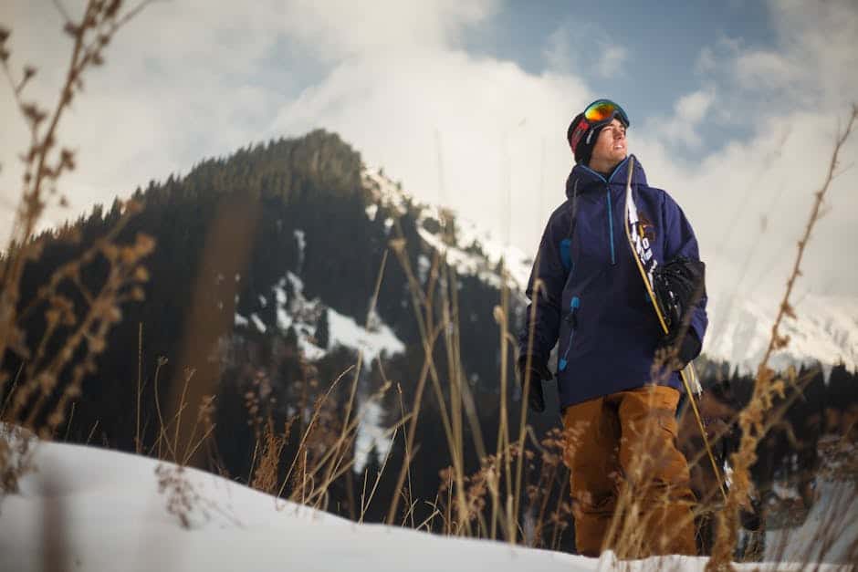 Vandretursudøver med skiudstyr i sneklædt bjerglandskab.