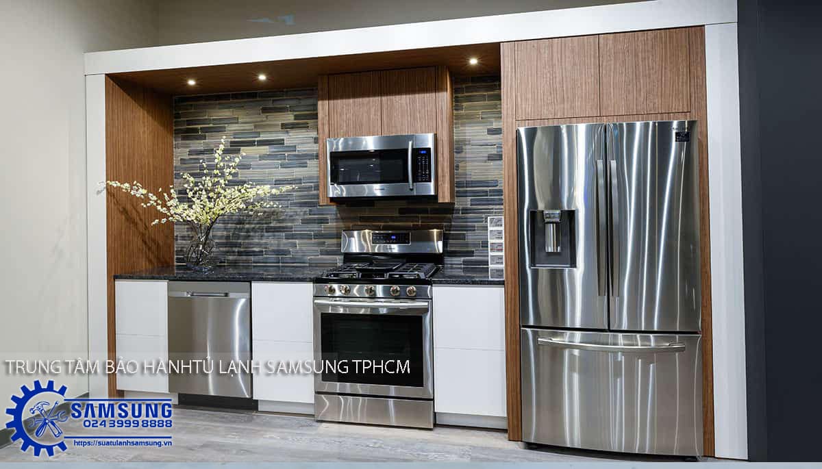 Stainless steel Samsung side-by-side refrigerator, modern kitchen display with built-in microwave, oven, and stylish wooden accents. Perfect for efficient kitchen storage and appliance integration.