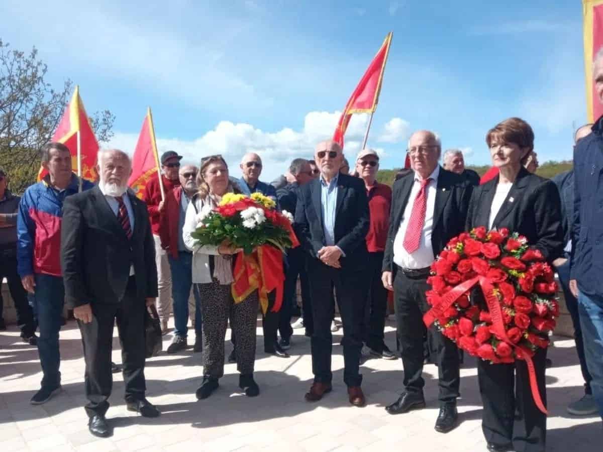 Mještani i predstavnici na komemoraciji sa zastavama i vijencima.